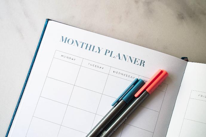 a planner with two pens sitting on top of it